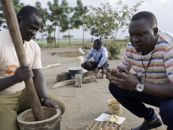 Ernest Oniba helping Salvado pound the fresh ingredients